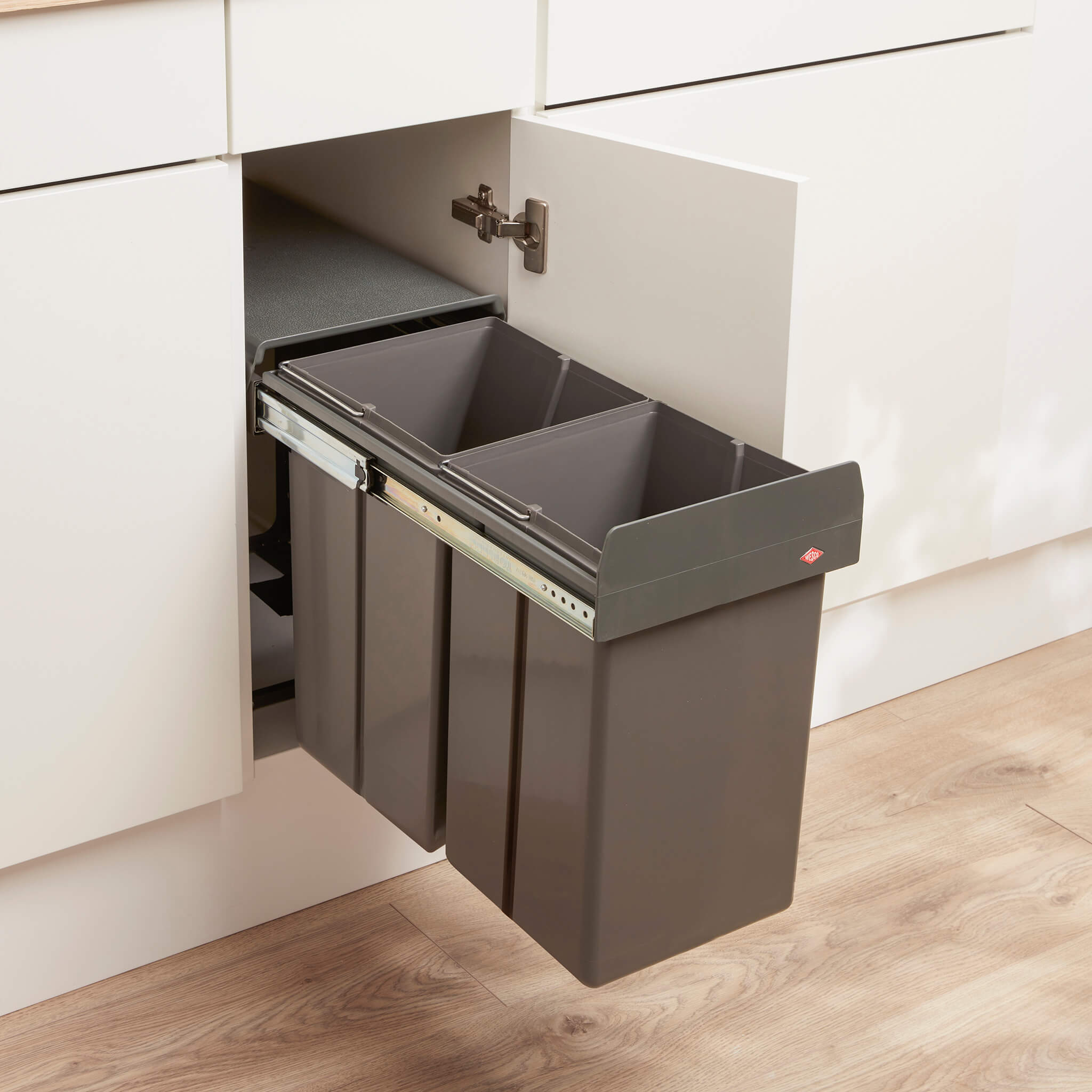 Pull-out Wesco bin in a kitchen cabinet with a neutral colour scheme.
