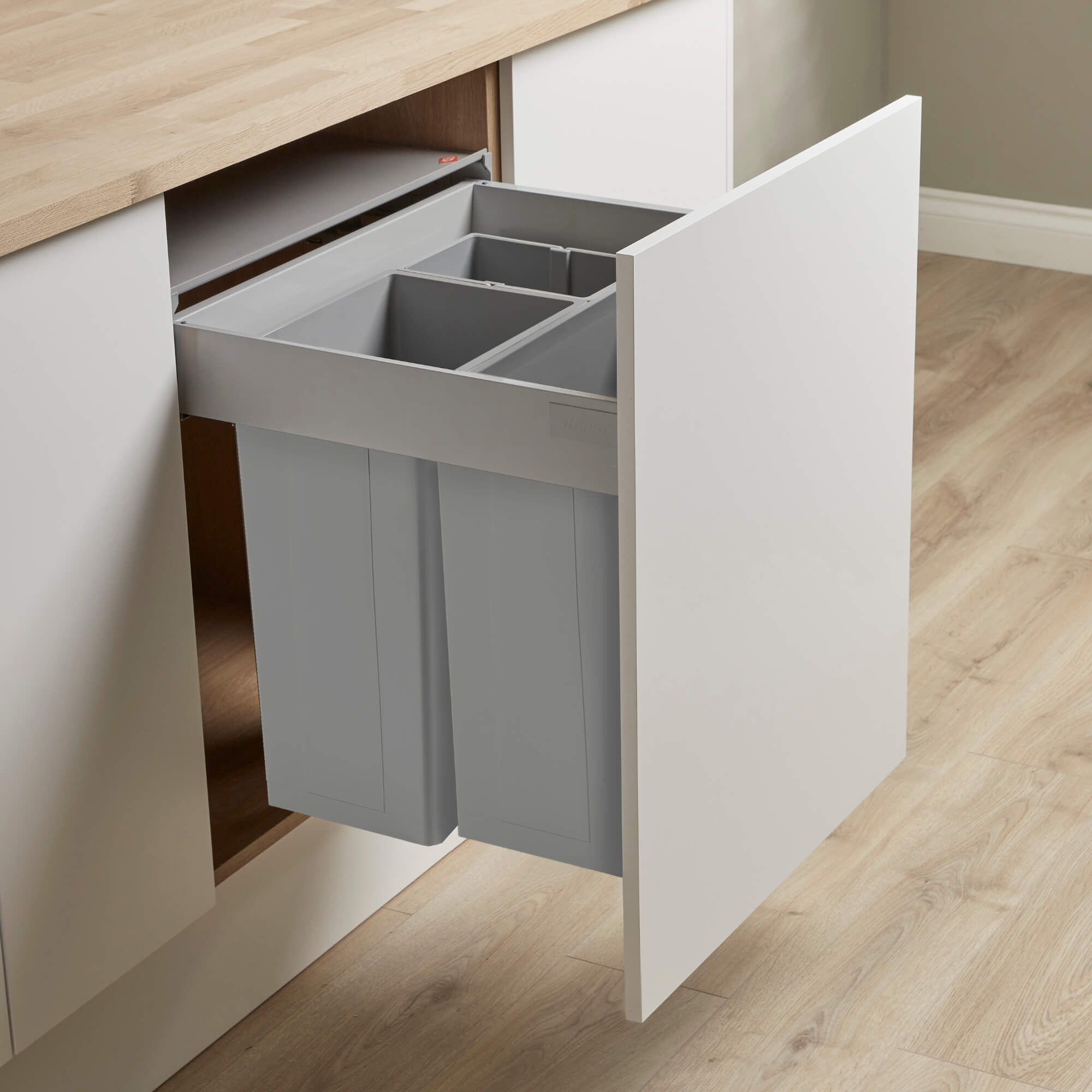 A light grey Wesco Pullboy Z BIG integrated recycling bin with three compartments, mounted within a Blum Antaro drawer, designed to be pulled out from a kitchen cabinet.