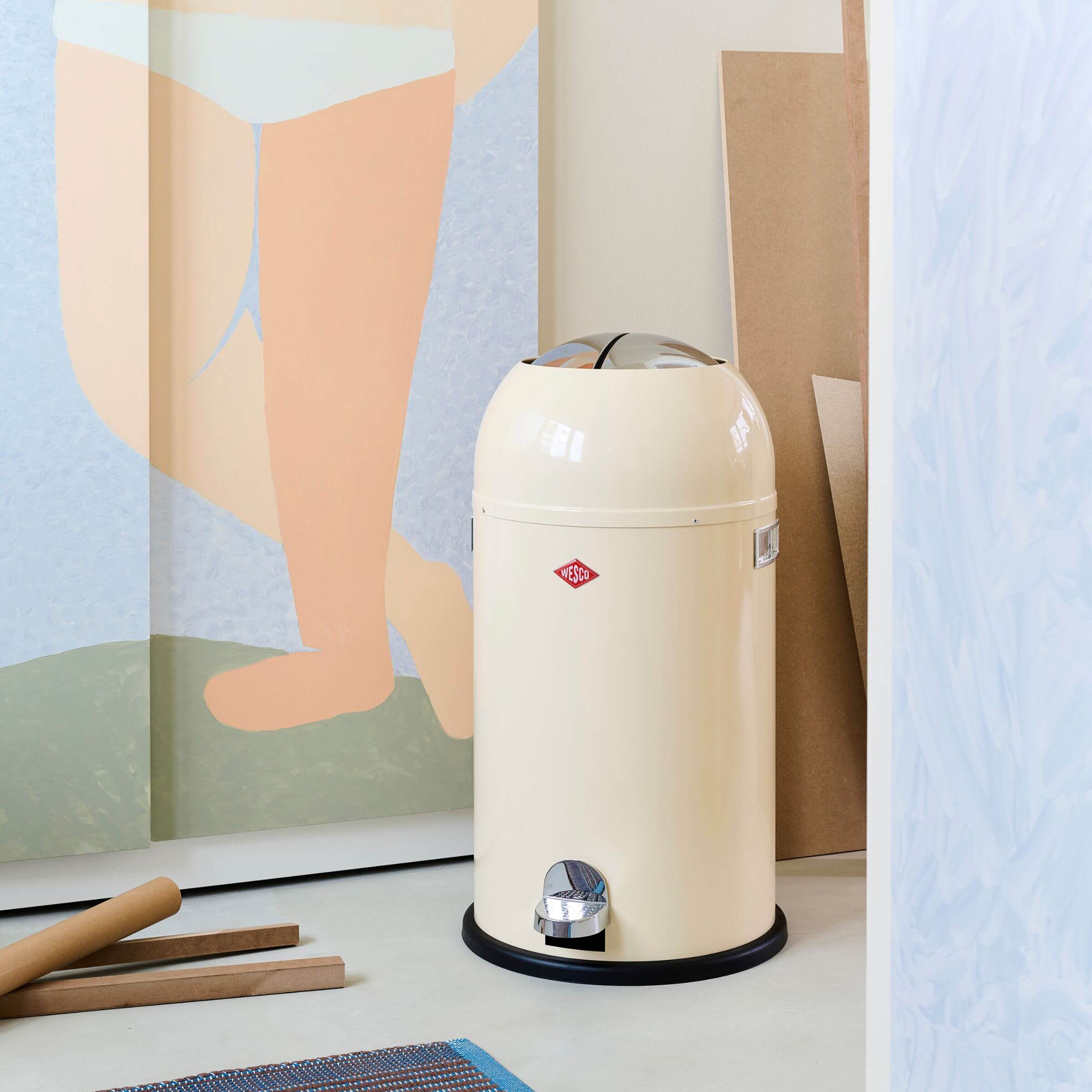Cream Pedal bin with Wesco brand logo in a room setting