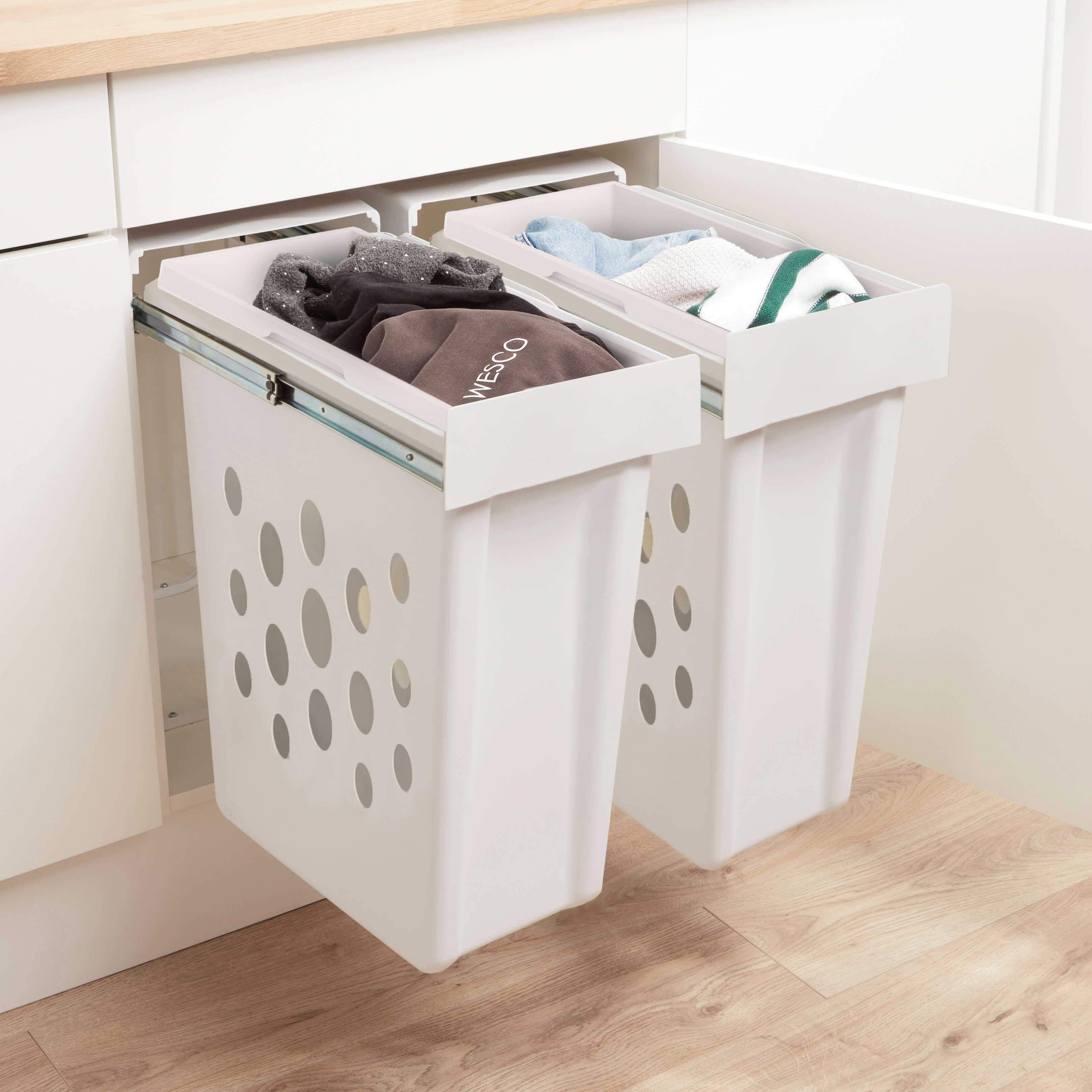 Wesco Laundry boy twin pull-out with clothes in baskets. Installed in White kitchen cabinets