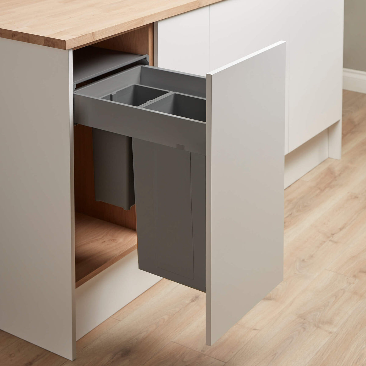 Wesco Pullboy Z pull-out kitchen waste bin for Blum Merivobox in dark grey for a 400mm cabinet with 2 compartments. Installed in a cabinet with white doors and wooden floor and worktop.