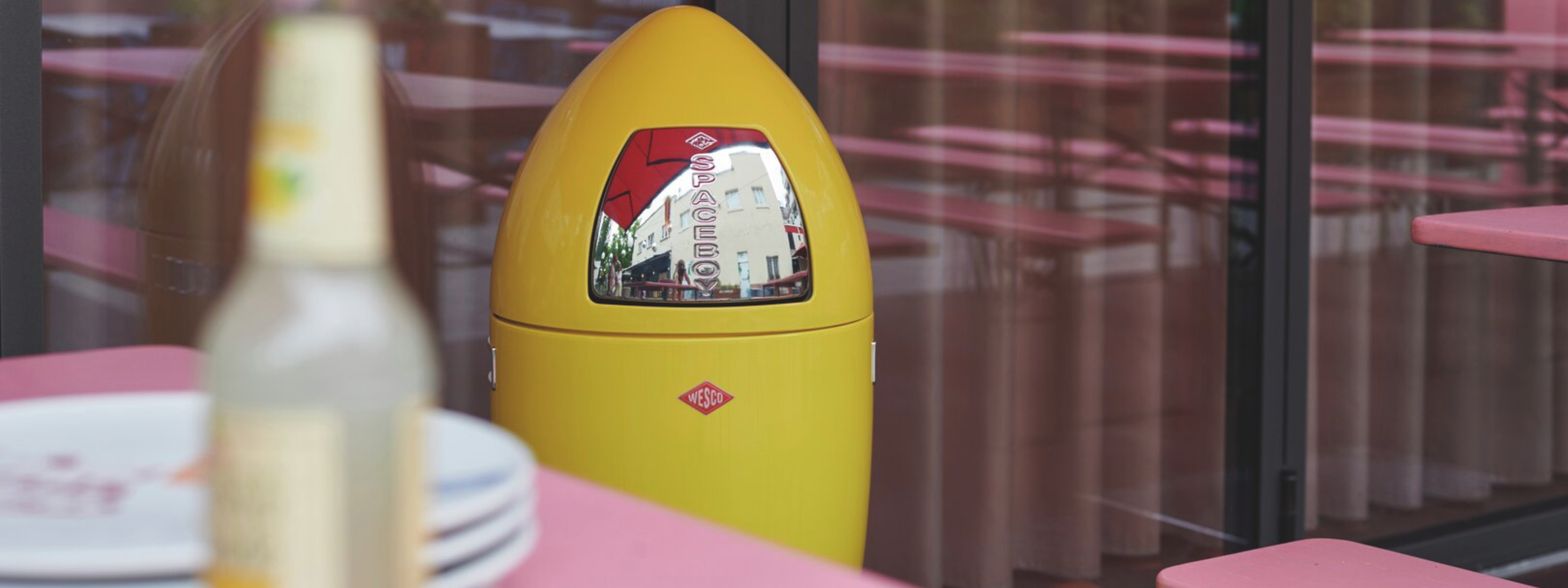 Wesco Spaceboy XL 35L free-standing waste bin in Lemon yellow, picture outside in a restaurant
