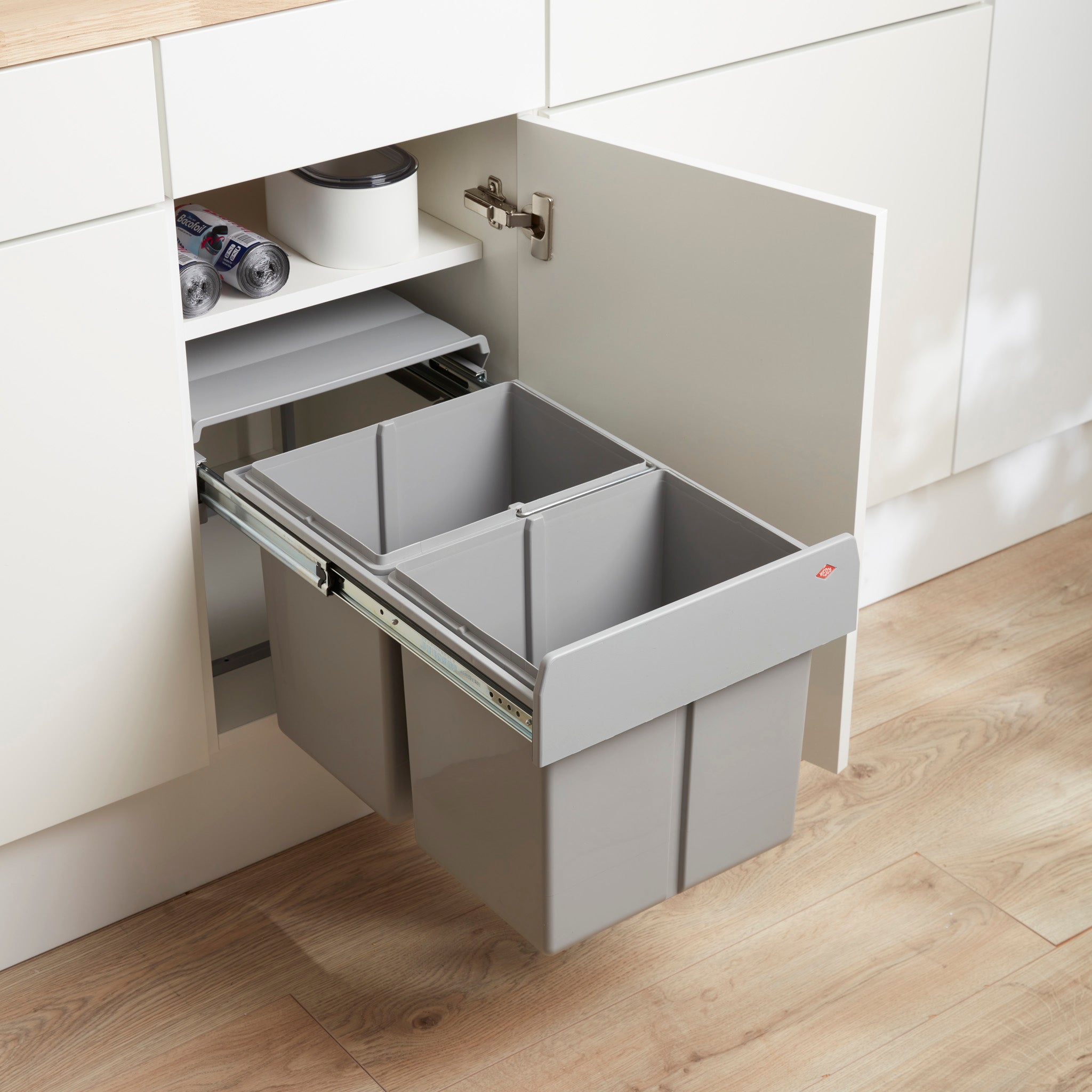 Alu grey Double Master 32L waste bin is pulled out from a kitchen cabinet, showing two separate bin compartments beneath a closed lid.