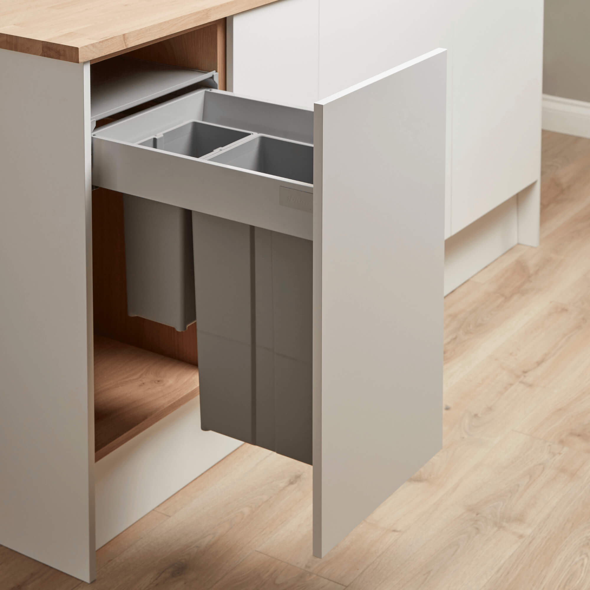 Wesco 400mm Integrated recycling bin system with two compartments partially installed in a kitchen cabinet.