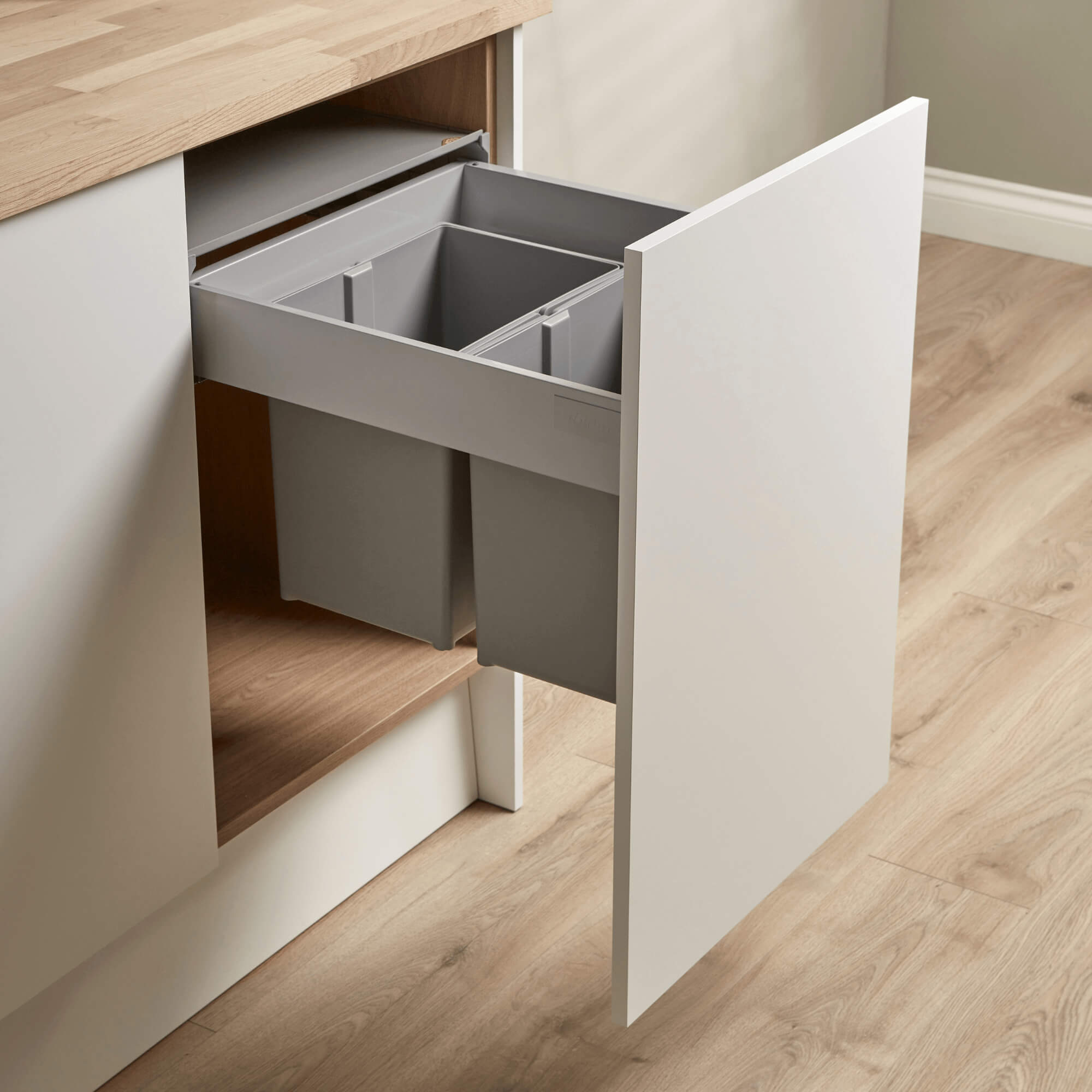 Integrated Wesco Pullboy Z recycling bin system 450m with two compartments, light grey inner bins with handles, mounted within a kitchen cabinet door.