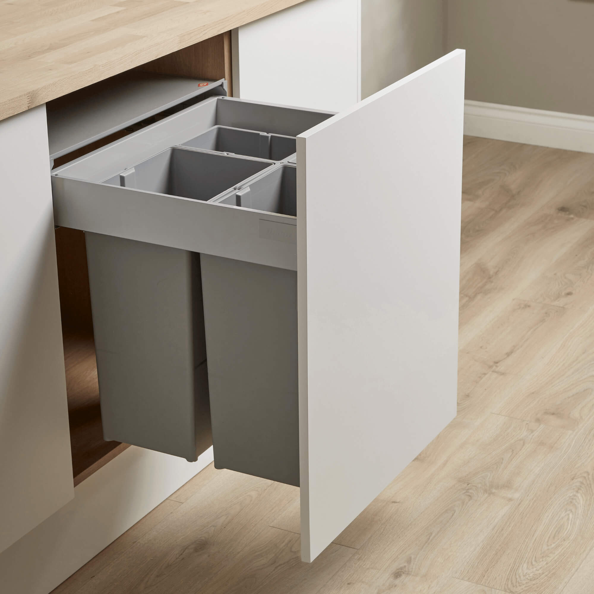 Wesco Pullboy Z integrated recycling bin system with a 600mm door, consisting of four compartments, installed in a kitchen cabinet.