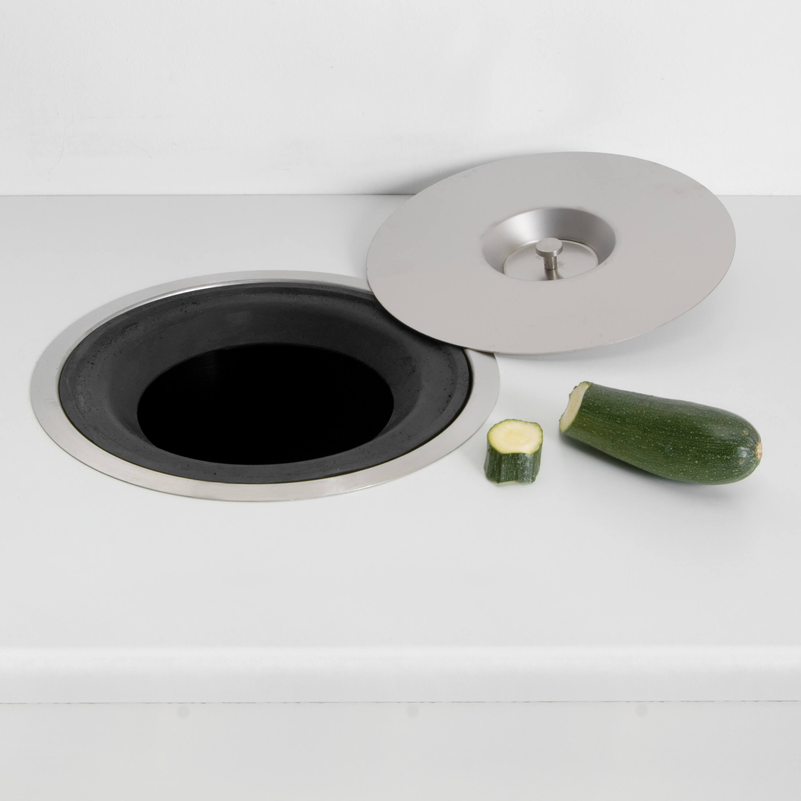 A stainless steel worktop bin with a black inner bucket, with stainless steel lid