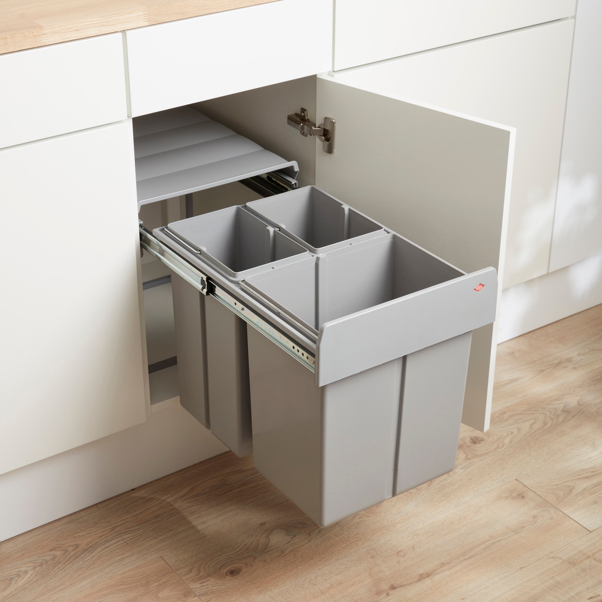 A Alu Grey Trio Master Maxi waste bin installed inside a kitchen cabinet, featuring three separate bins 