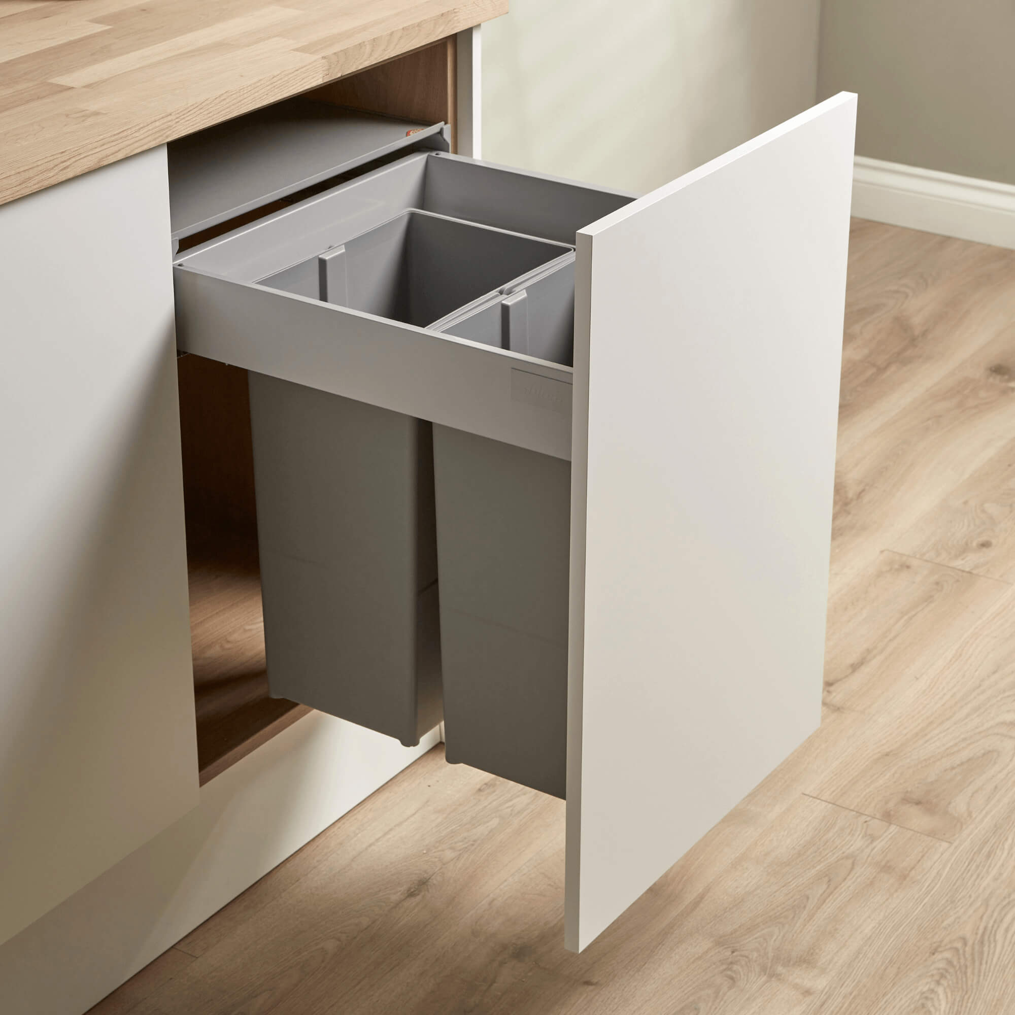 Wesco Pullboy Z integrated recycling bin system 450mm with two compartments, light grey in colour, mounted within a kitchen cabinet door.