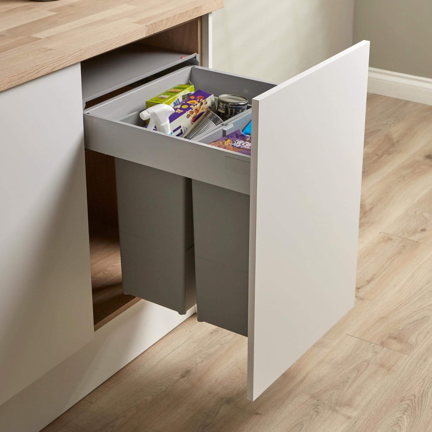 Wesco Pullboy Z 450mm integrated recycling bin system with two compartments, light grey in colour, filled with recycling, mounted within a kitchen cabinet door.