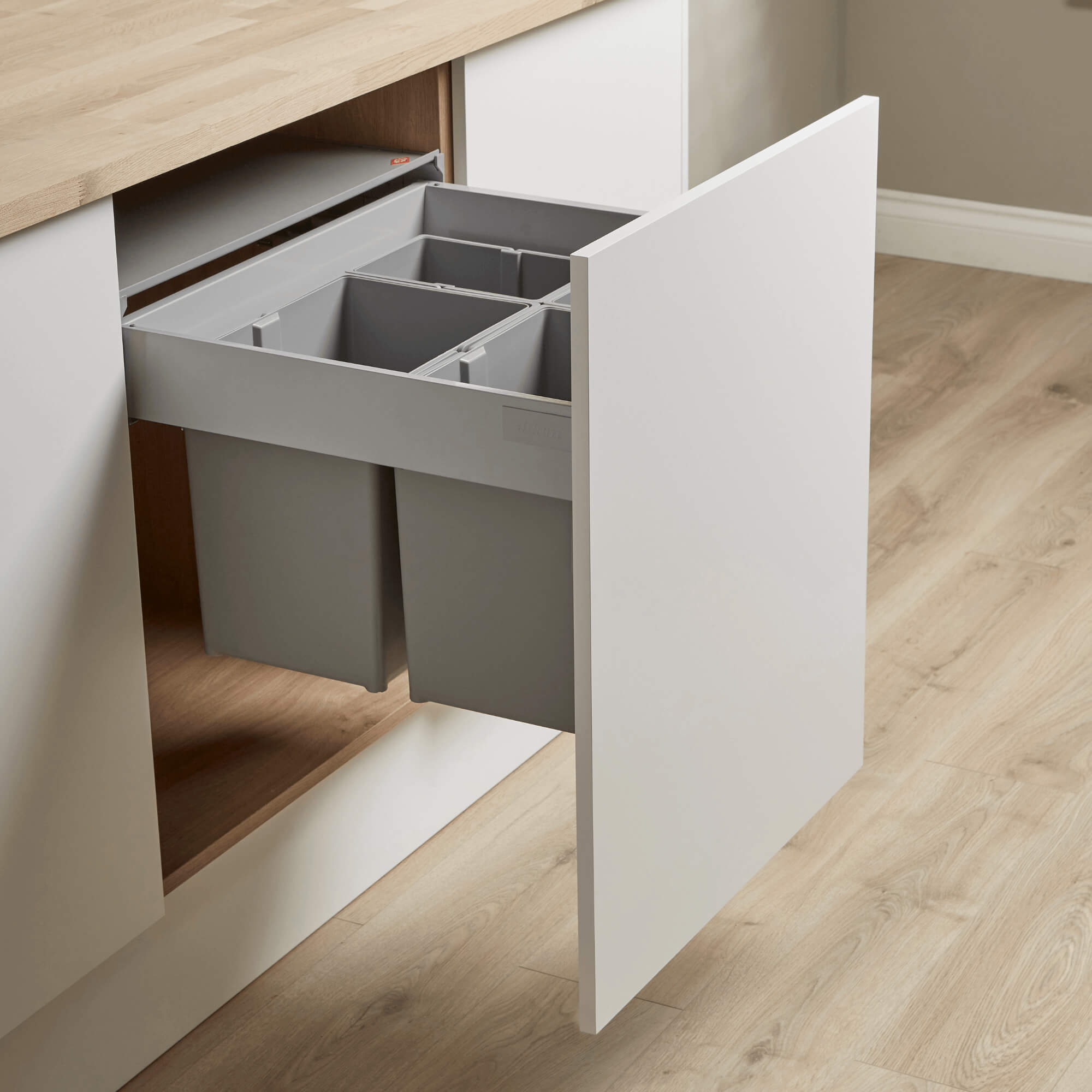 Wesco 600mm Pullboy Z integrated recycling bin system with four compartments, light grey inner bins with double handles, mounted within a kitchen cabinet door.