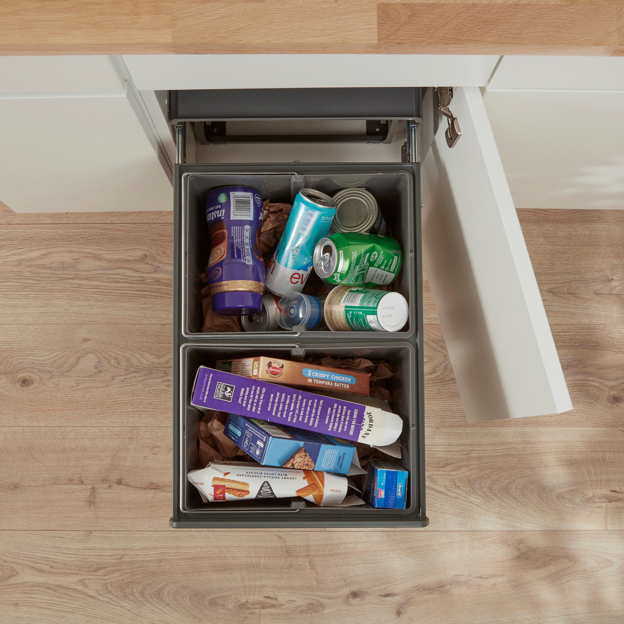 Above lifestyle image of the Wesco Profiline Double Master 40L. 2 compartments pull-out of the cabinet showing recycling waste.